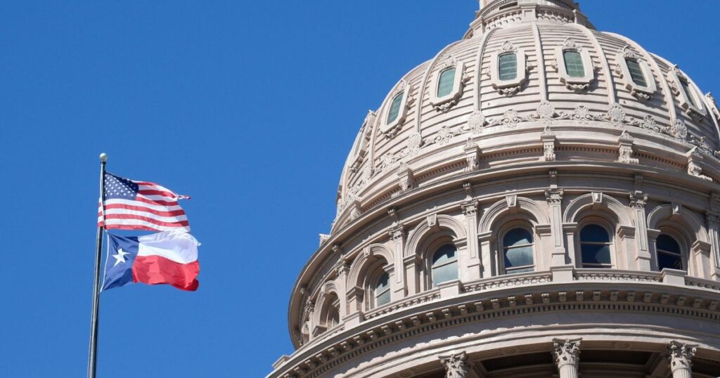 The Texas State Capitol dome in Austin with the U.S. and Texas flags.