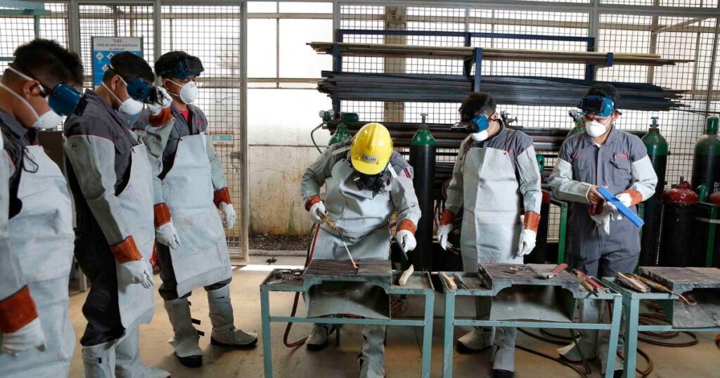 Workers in protective gear taking part in a safety training session in a factory.