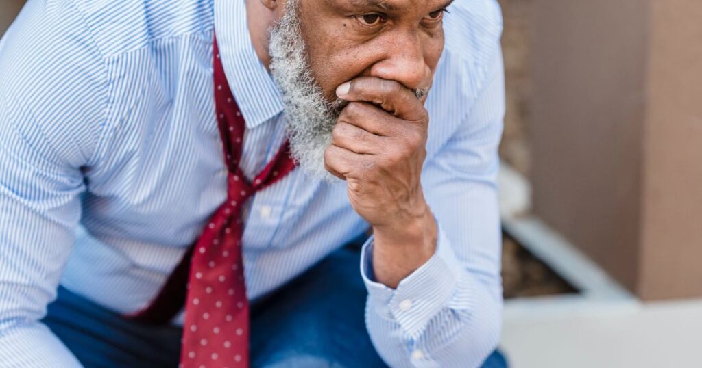 Worried businessman sitting on a city street after a hard day.