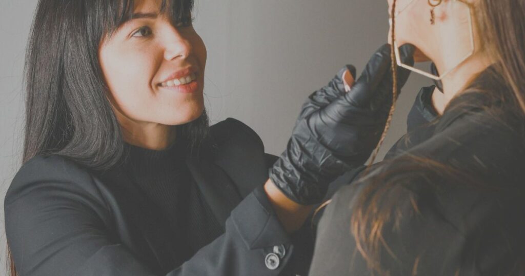 A hair stylist working on a client's hair in a salon.