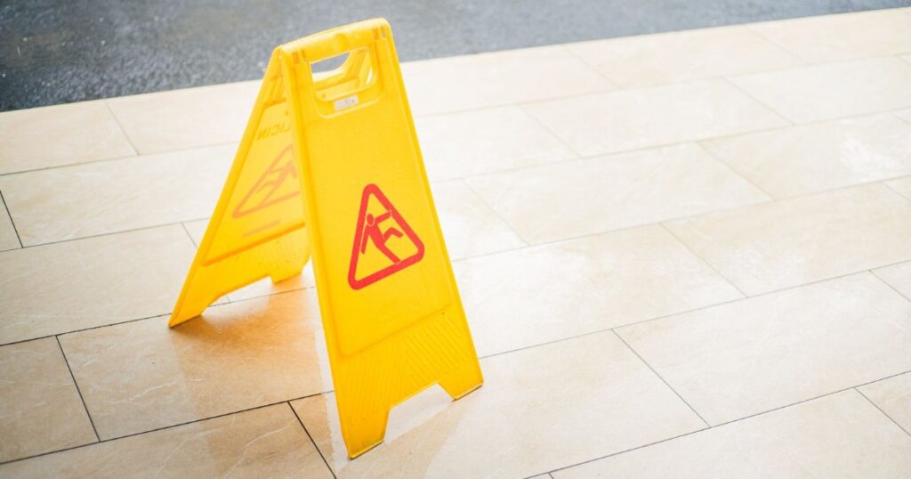 Yellow wet floor caution sign on a tile floor.