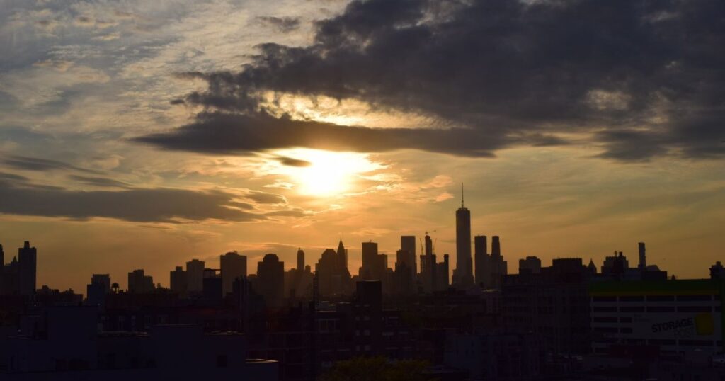 New York City skyline silhouetted at sunset.
