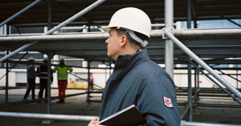 Construction supervisor inspecting scaffolding on a job site