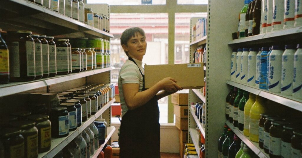 Store employee stocking shelves in a small retail shop